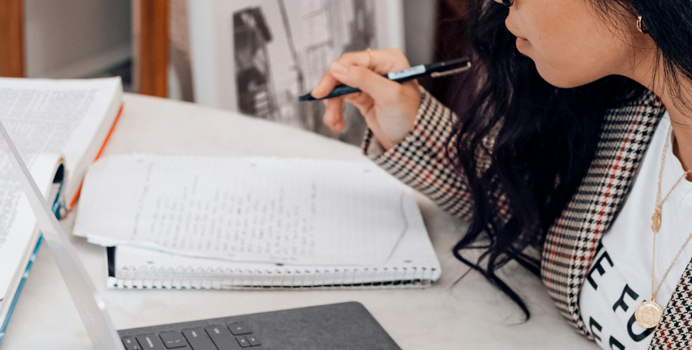 Pessoa fazendo anotações à mão num caderno